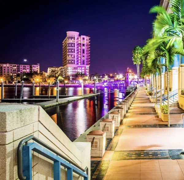 The Tampa Riverwalk lit up at night along the water